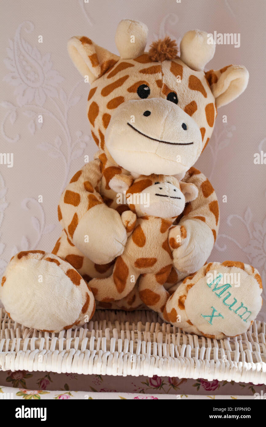 giraffe soft cuddly toy with baby and mum x on foot sitting on wicker basket Stock Photo