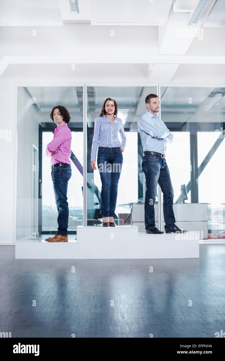 Three colleagues on podium in office Stock Photo