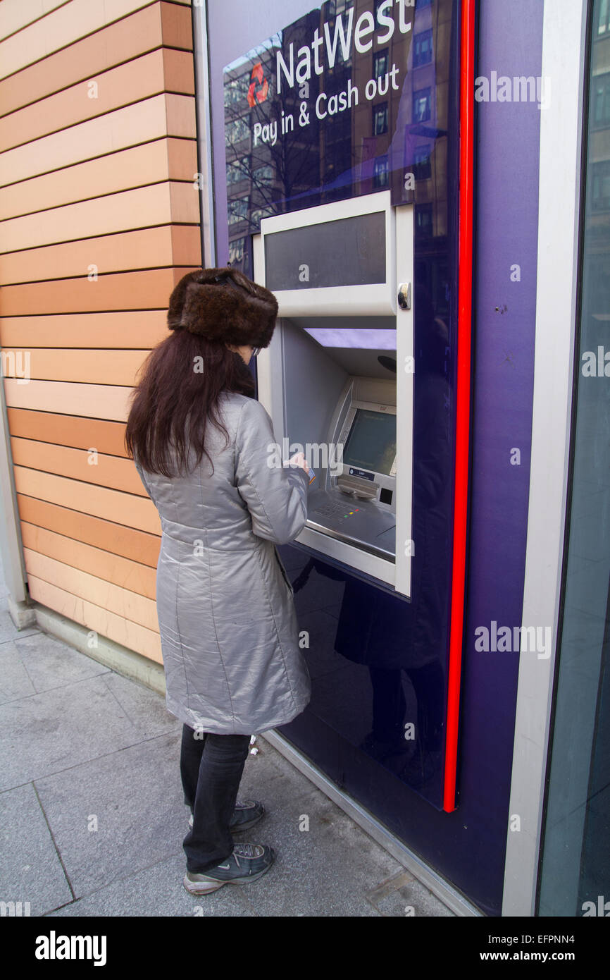 woman withdrawing cash from Nat West ATM machine in London Stock Photo