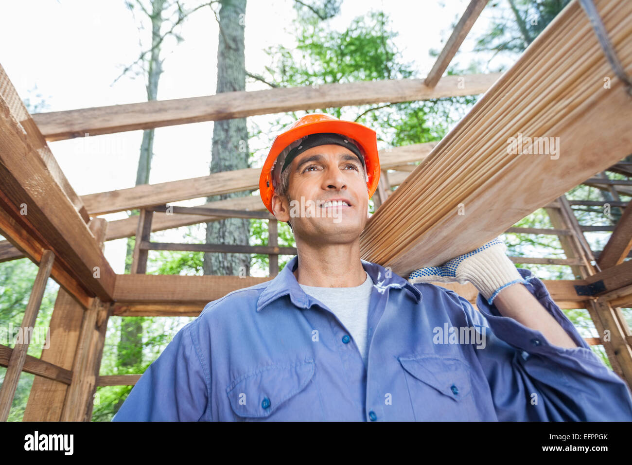 Construction Worker Carrying Wooden Planks Stock Photo - Alamy