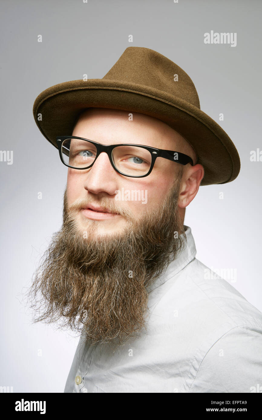 Studio portrait of mid adult man in trilby with overgrown beard Stock Photo