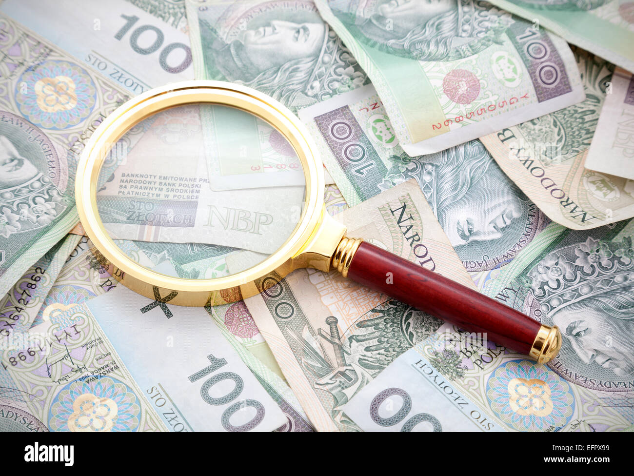 Magnifying Glass On A Few Stacks Of Money Coins Stock Photo