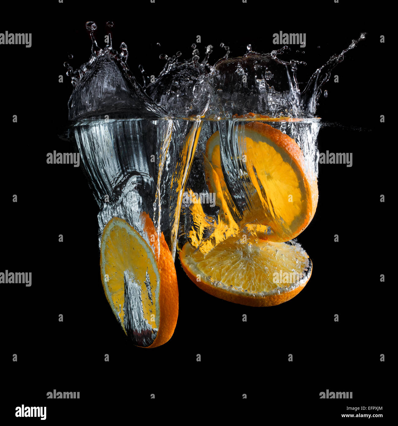Orange slices falling into the water with a splash. Photo on black ...