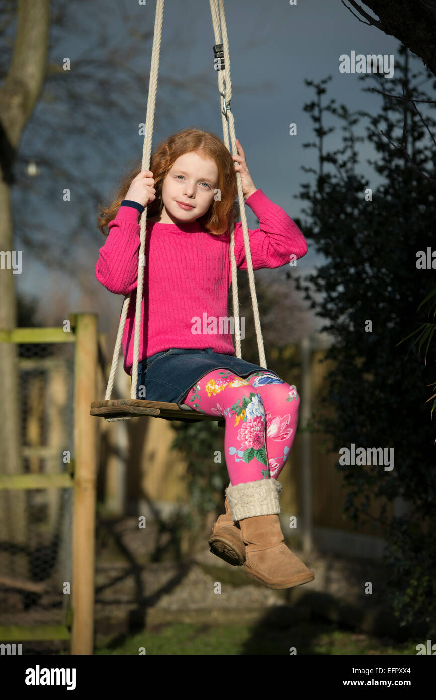 Portrait of a little girl on a garden swing Stock Photo - Alamy