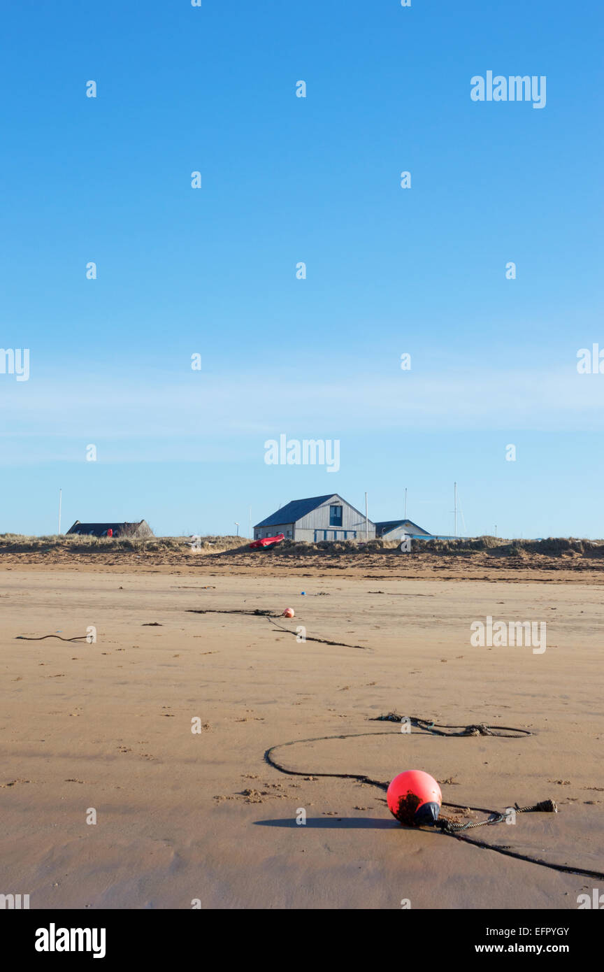 Elie beach at low tide with fishing buoy in foreground and yacht houses