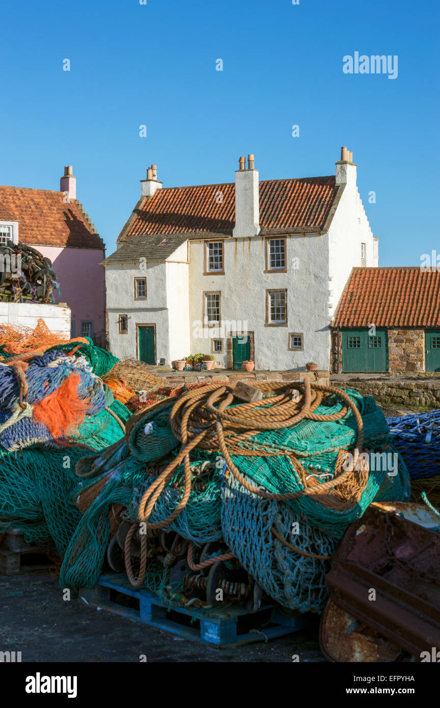 Traditional Scottish fishing harbour with cottage and fishing nets
