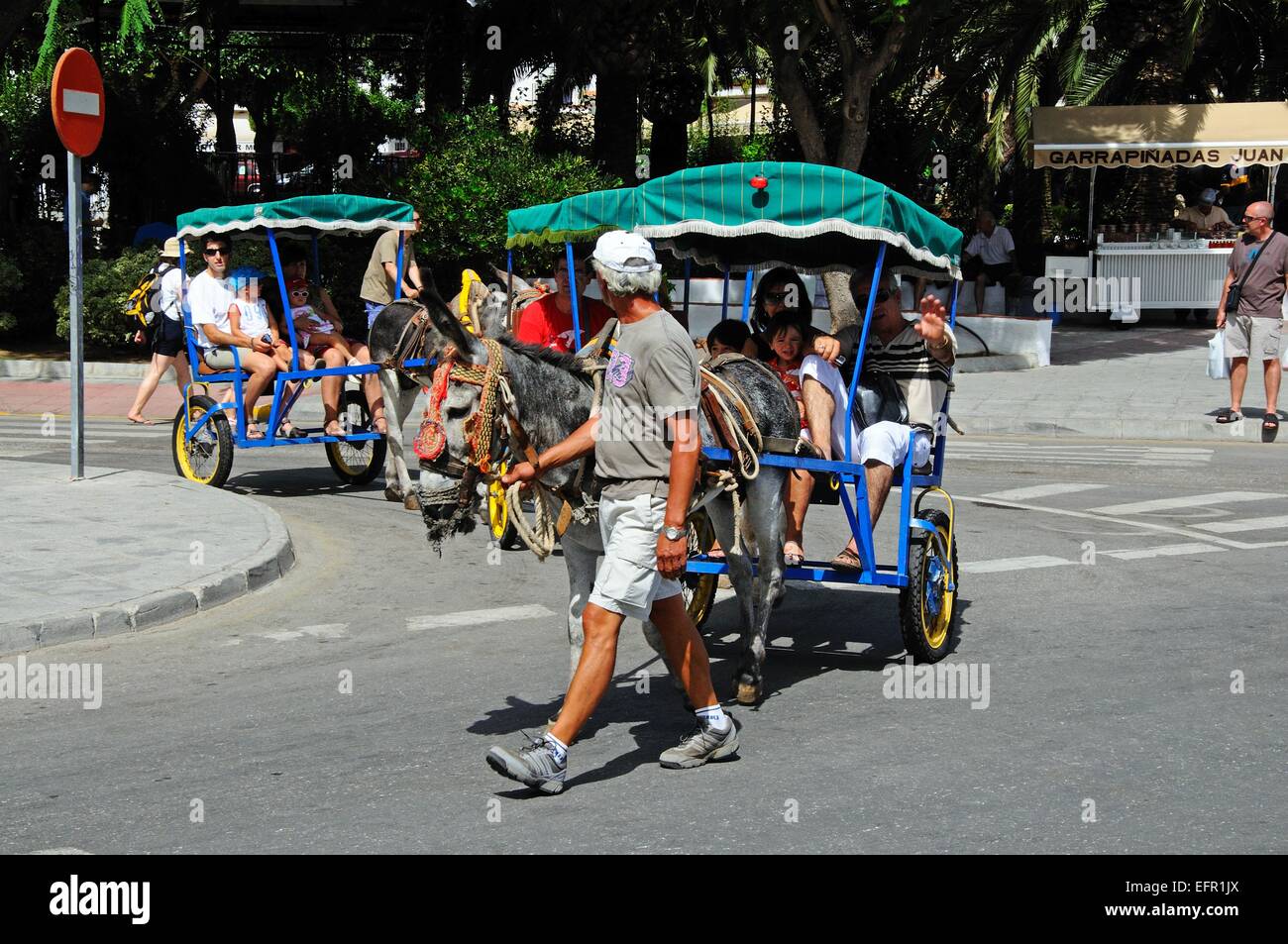 People taking a donkey ride led by a Spanish man in the town centre