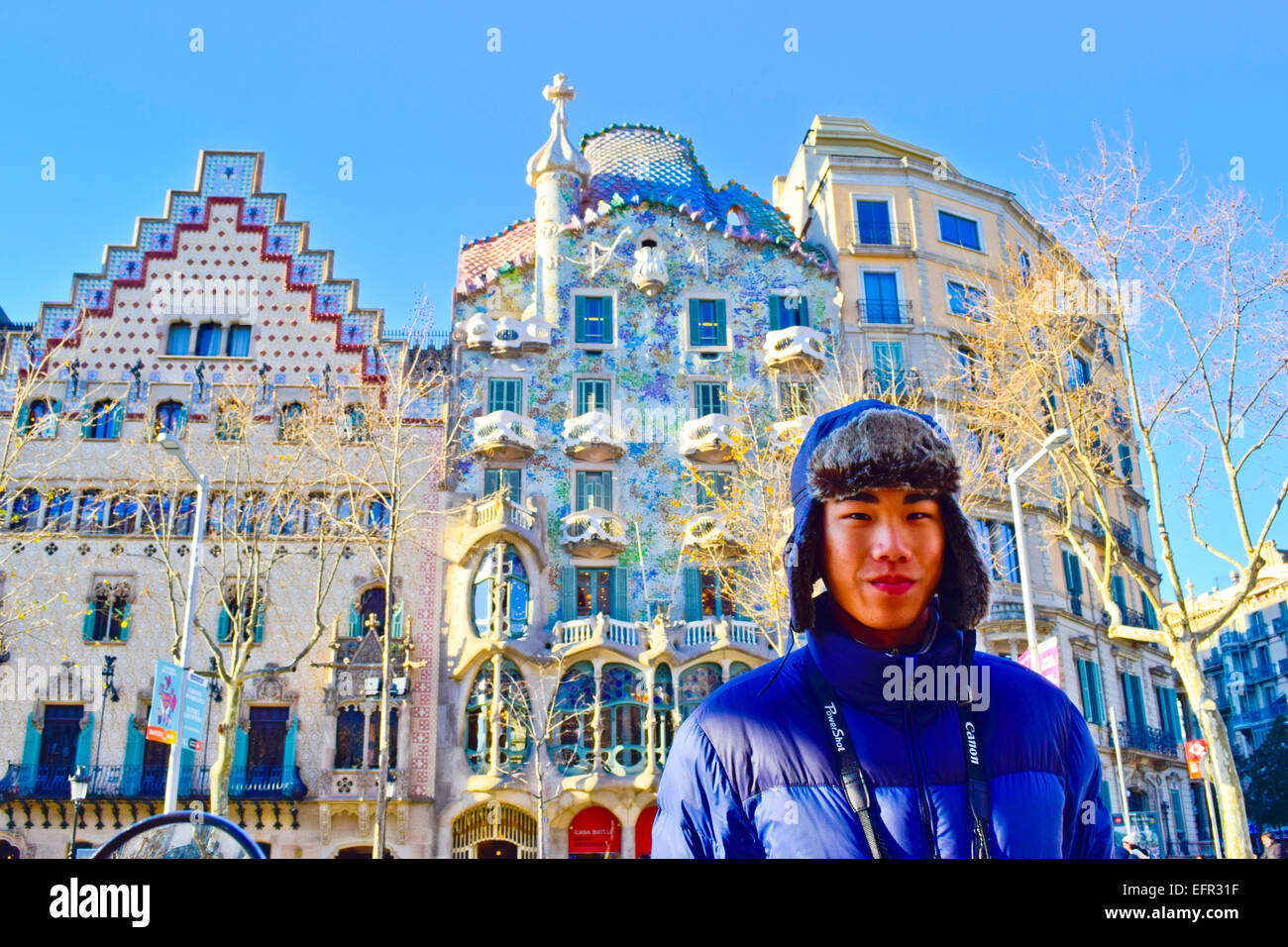 Portrait. Asian young man with winter hat. Amatller House by Puig i Cadafalch. Batllo House by Antoni Gaudi. Barcelona, Catalonia, Spain. Stock Photo