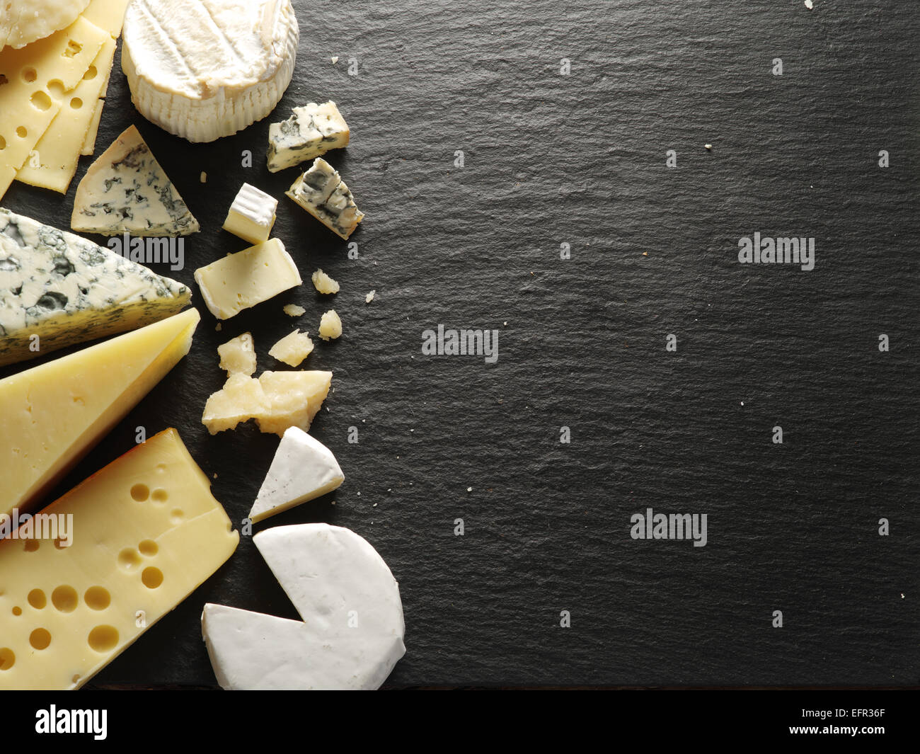 Different types of cheeses on black board. Stock Photo