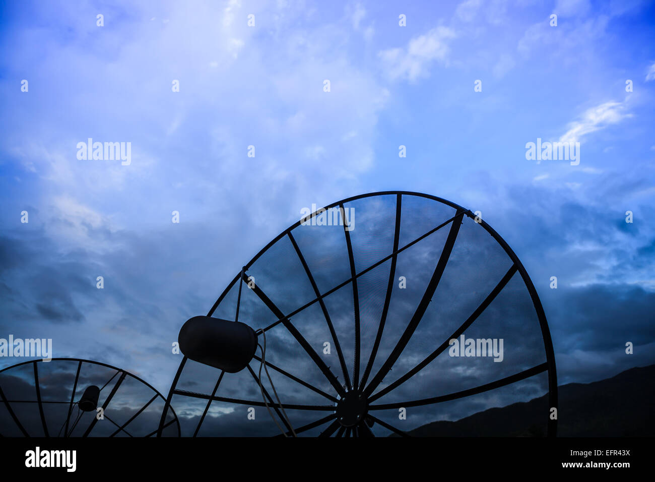 Double black Satellite dish against blue cloudy sky in early morning Stock Photo