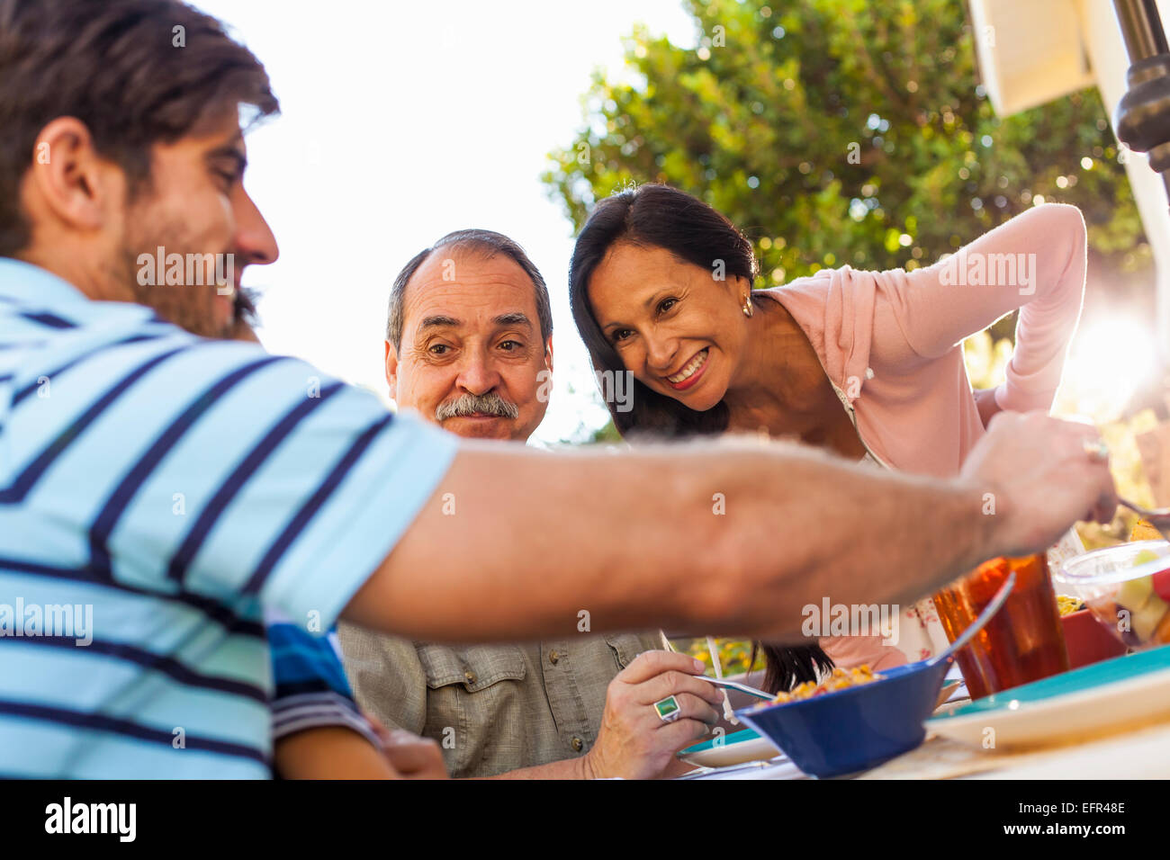 Three generation family dining in garden Stock Photo