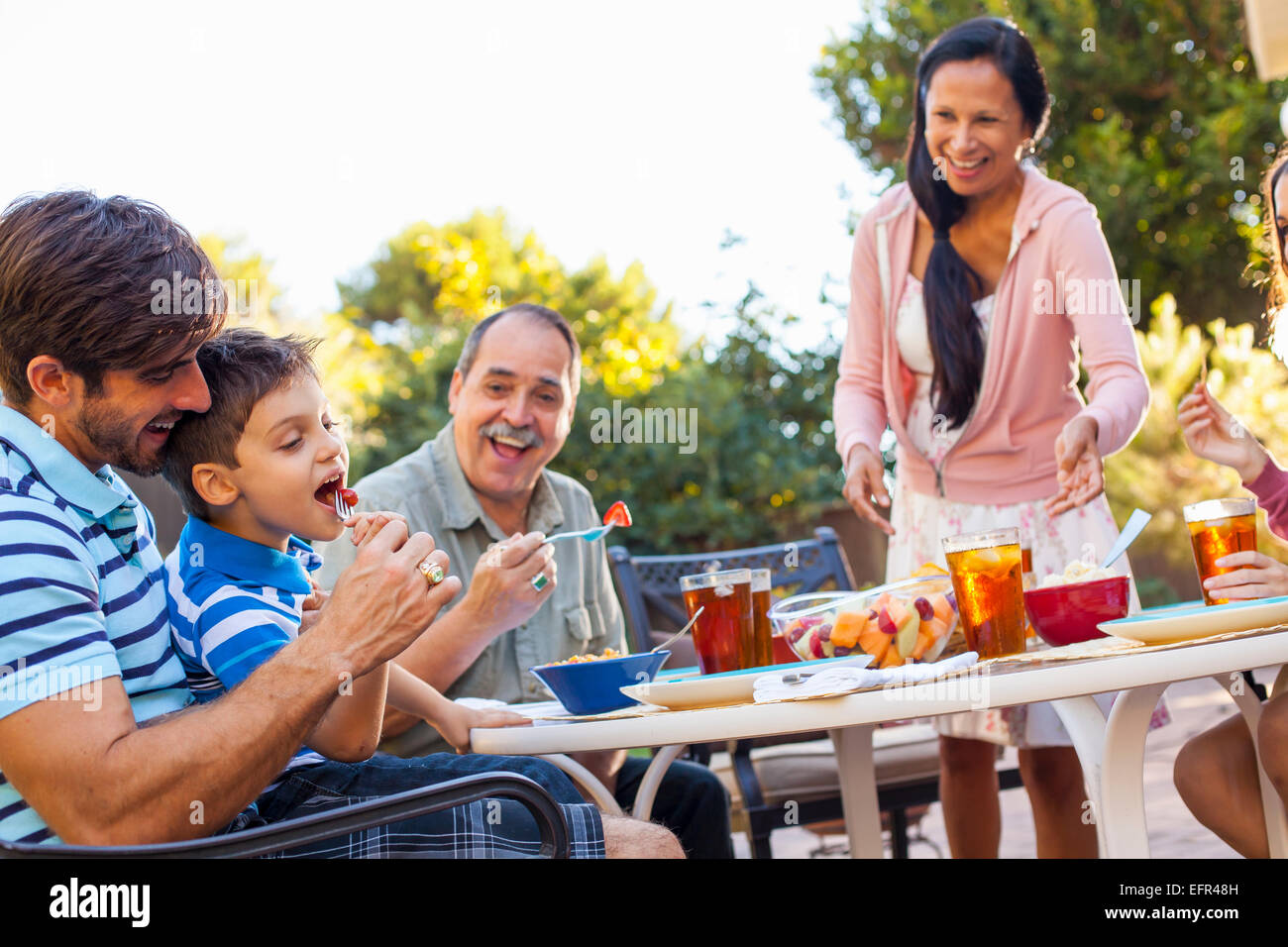 Three generation family dining in garden Stock Photo
