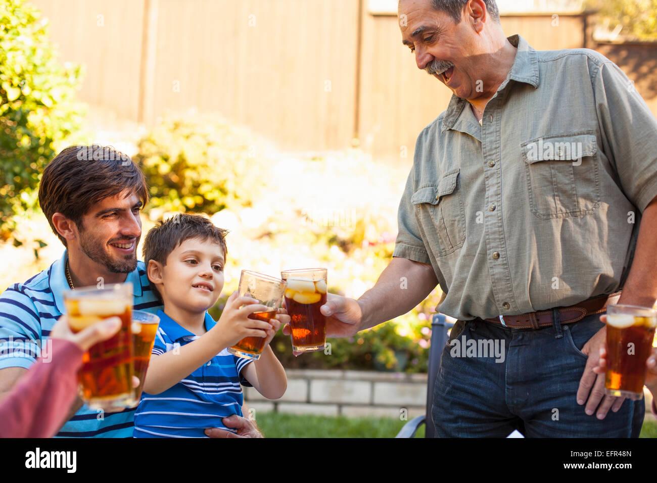 Three generation family toasting in garden Stock Photo