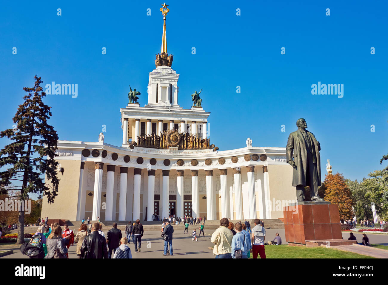 People walking in front of the Main Pavillion at the All-Russia Exhibition Centre (VDNKh). Moscow, Russia. Stock Photo
