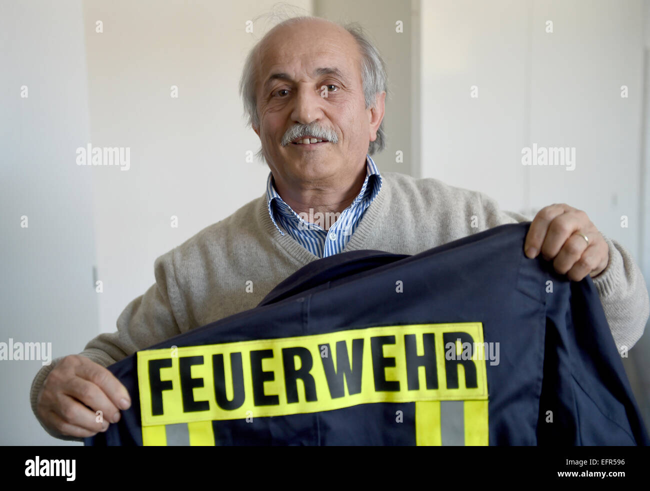 Kiel, Germany. 6th Feb, 2015. The chairman of the local Turkish congragation, Cebel Kucukkaraca, holds a jacket of the local fire department in his hands in Kiel, Germany, 6 February 2015. The Turkish community in Kiel is supporting a stronger engagement of its members in local social services such as civil protection and the fire brigade. Photo: Carsten Rehder/dpa/Alamy Live News Stock Photo