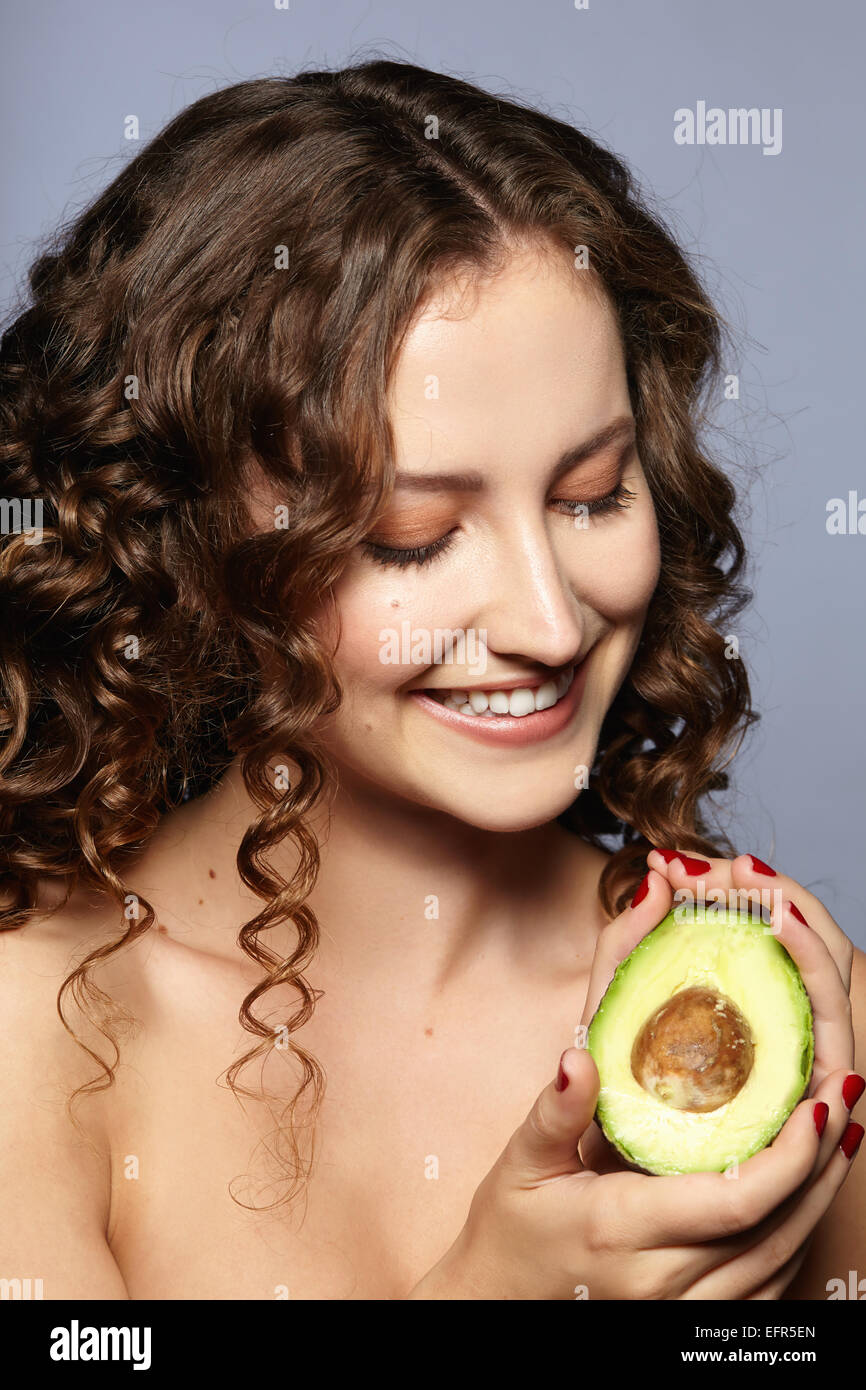 Female model holding halved avocado Stock Photo
