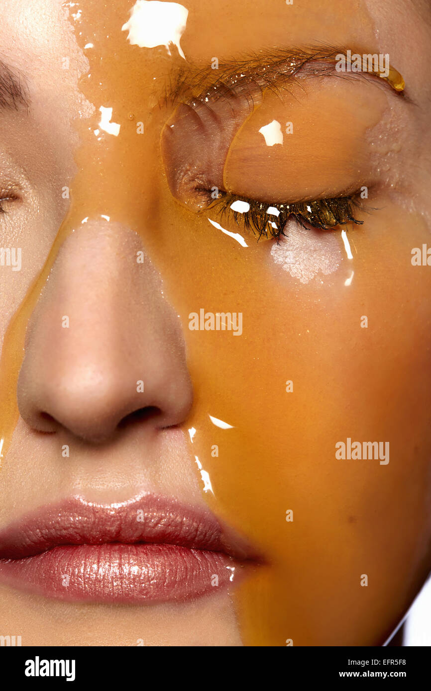 Female model's face covered in honey Stock Photo