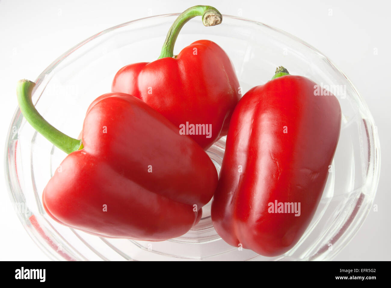 Three Red Peppers in a Glass Bowl Stock Photo Alamy