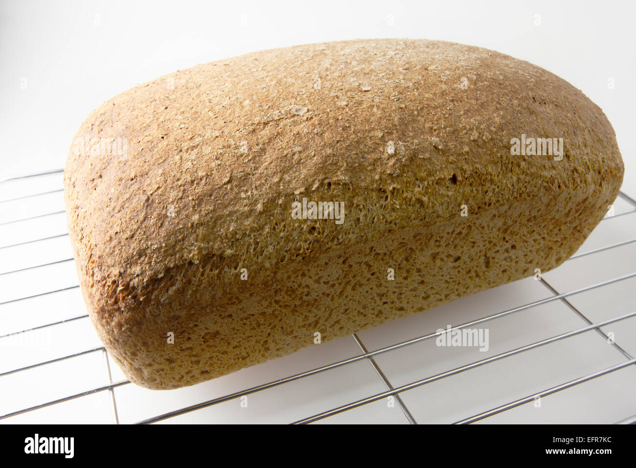 Loaf of Freshly Baked Wholemeal Bread on a Wire Cooling Rack Stock Photo