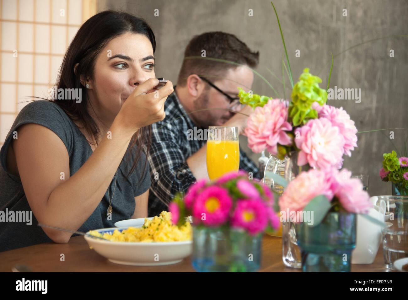Friends at dinner table eating meal Stock Photo