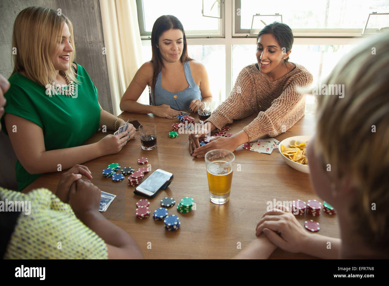 Group of friends playing cards around table Stock Photo