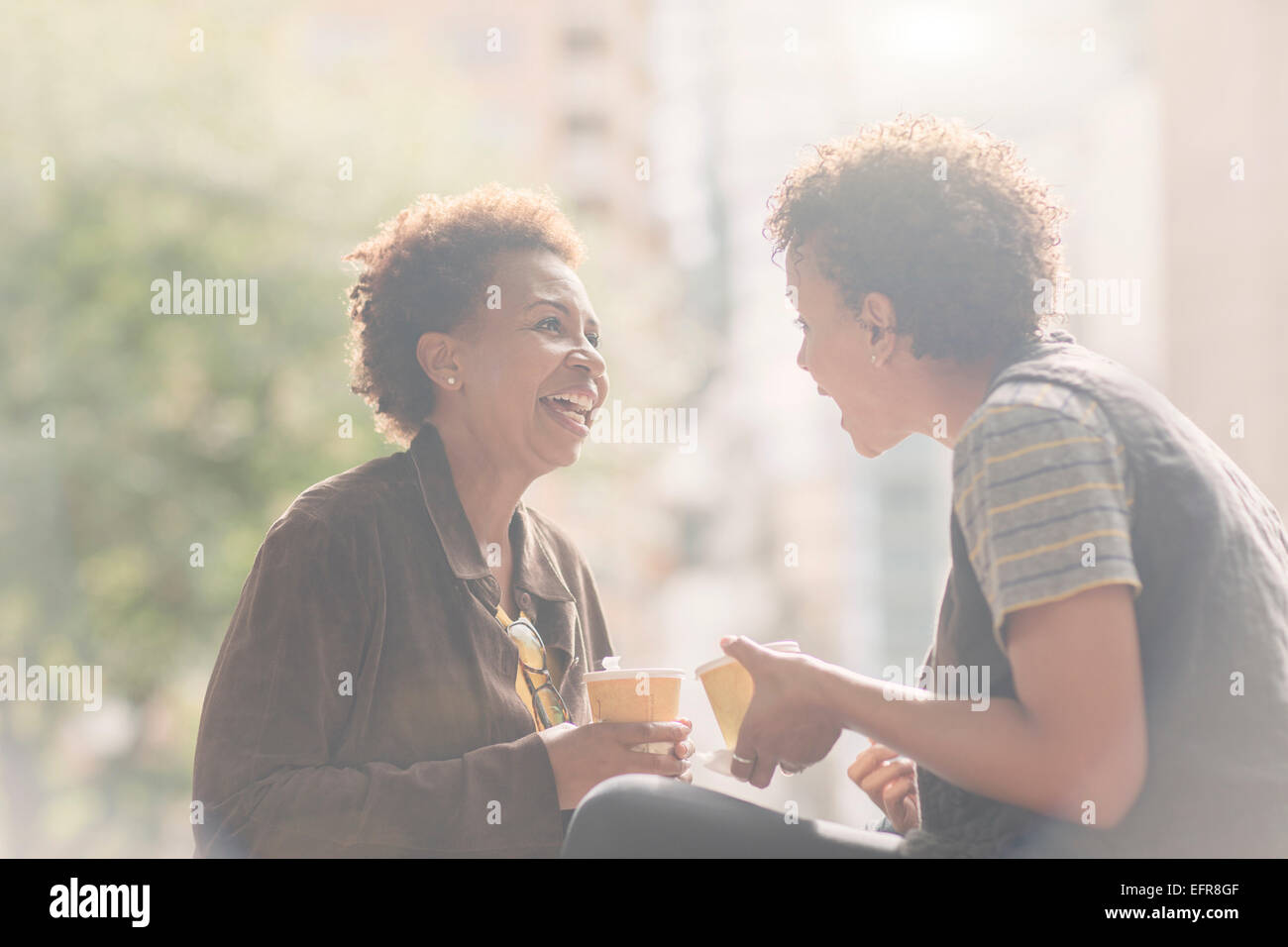 Two mature female friends chatting on street Stock Photo