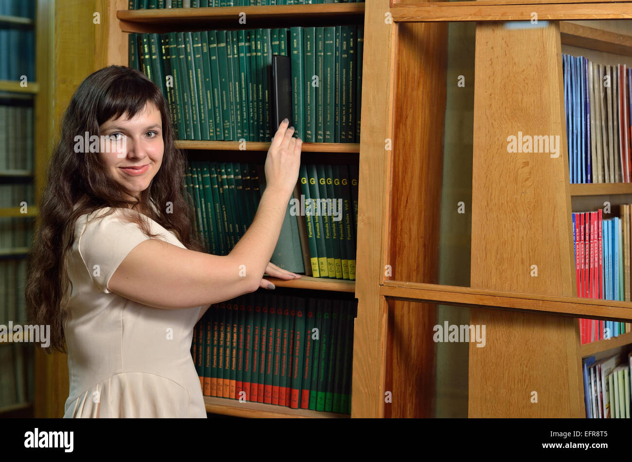 A woman with a gadget in the library Stock Photo