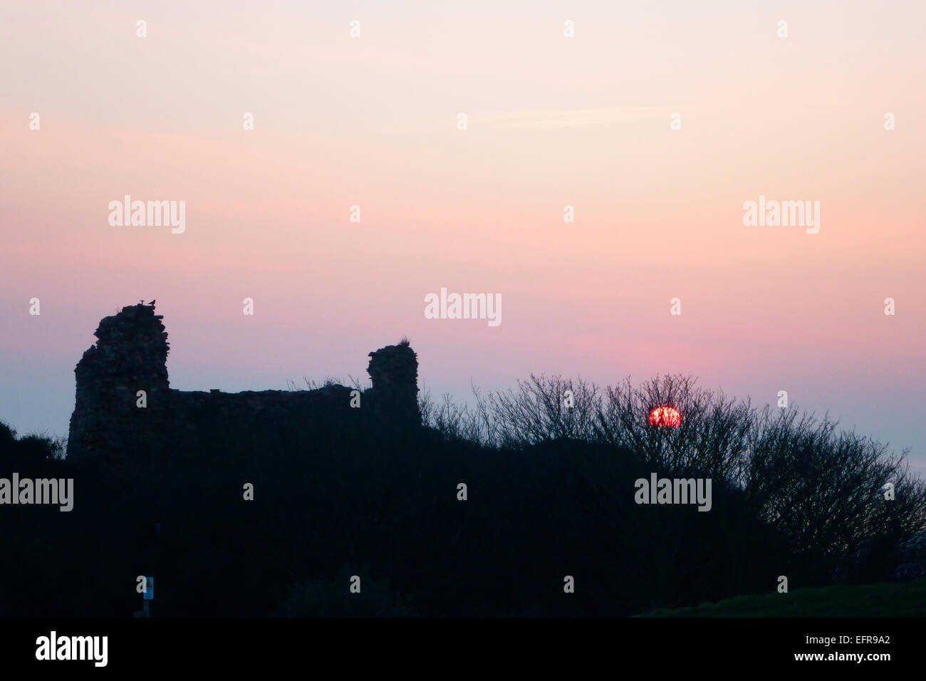 Misty winter sunset behind the silhouette of Hastings Castle, East Sussex, England, UK, GB Stock Photo