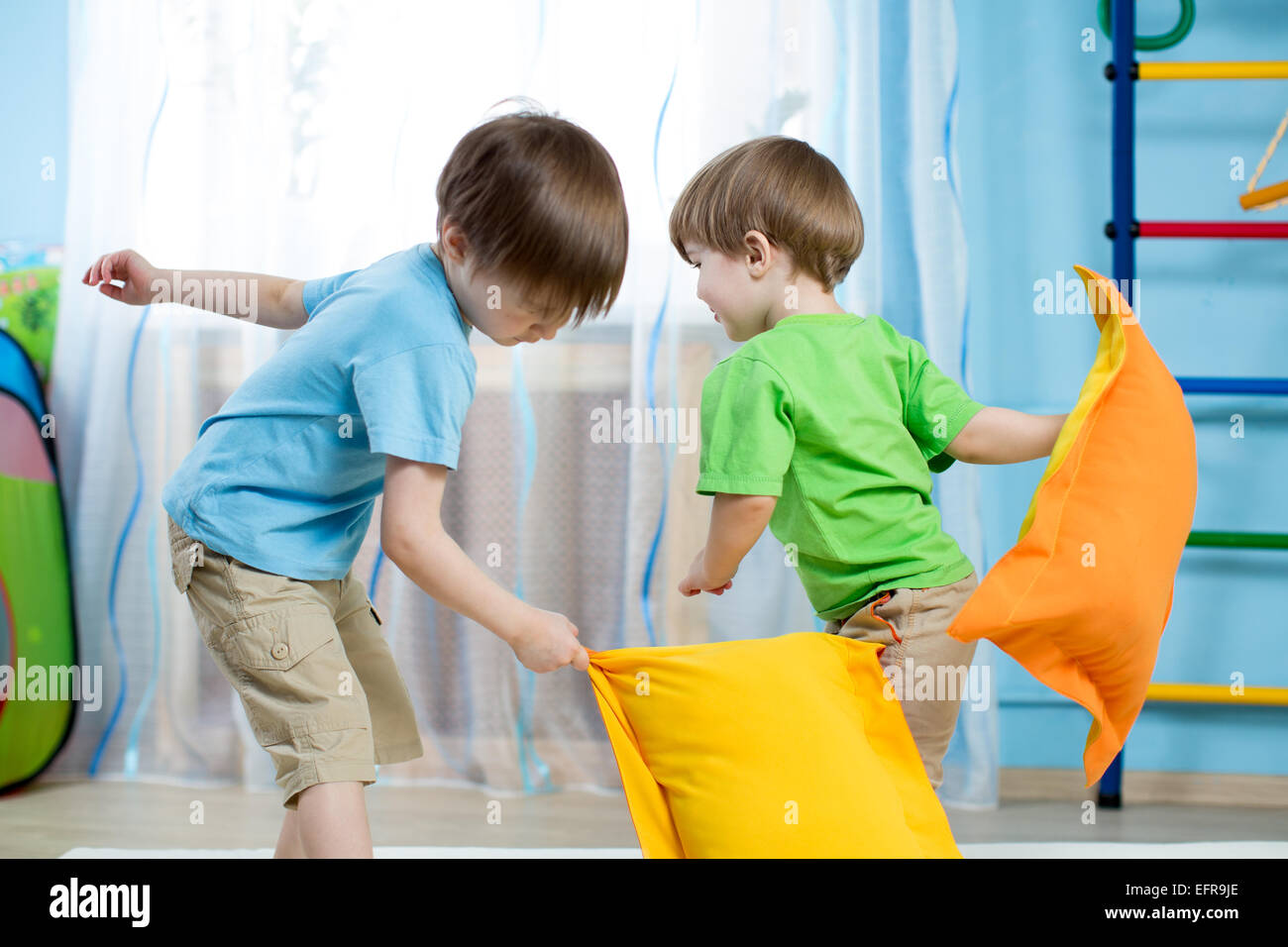 Two kids playing with pillows Stock Photo
