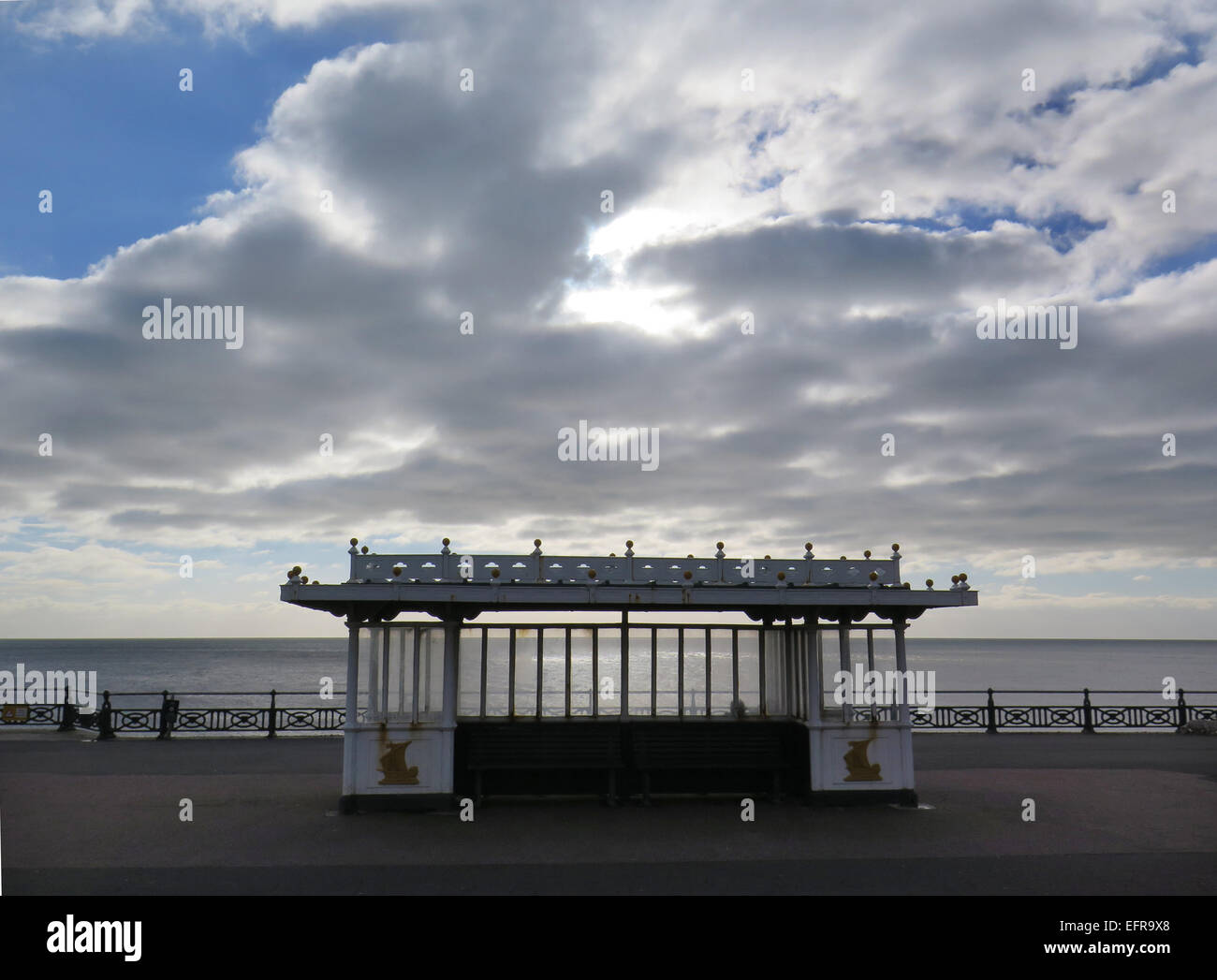 Cumulus clouds gather over a seafront shelter on  Hove Lawns promenade, Brighton and Hove, East Sussex. Stock Photo