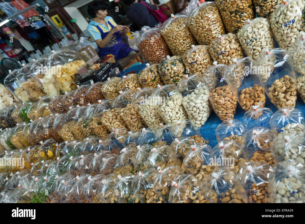 Horizontal close up of rows of plastic bags full of nuts and dried snacks in Thailand. Stock Photo