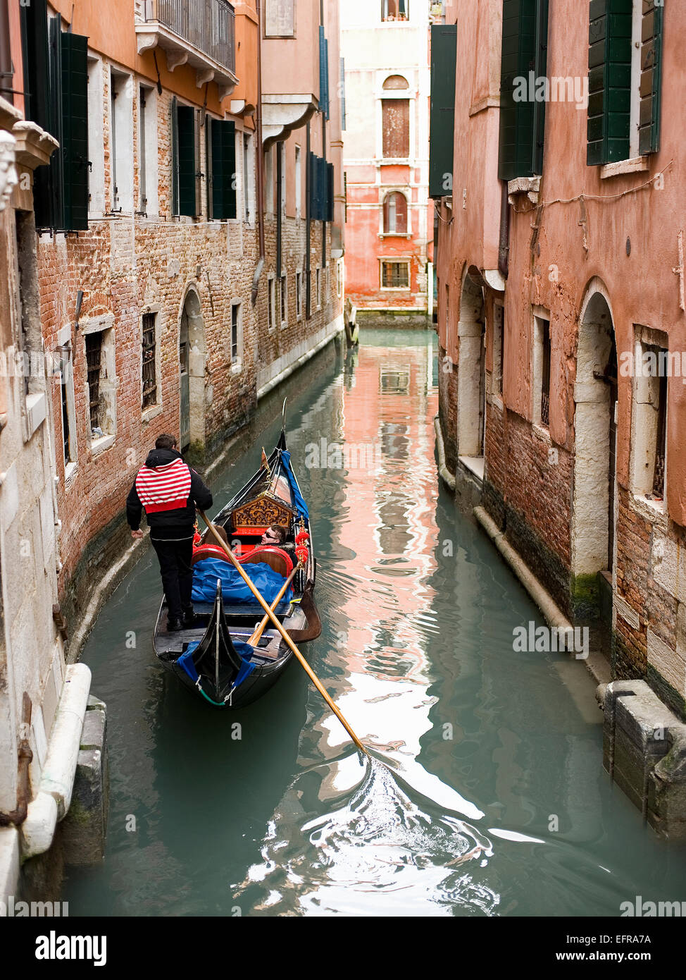 gondola with tourists, boat in canal in narrow waterway Venice Stock Photo