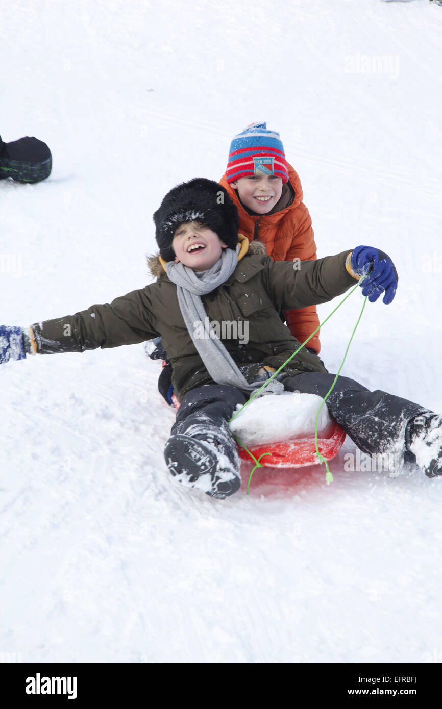 Two young boys enjoy sledding in Prospect Park, Brooklyn, NY. Stock Photo