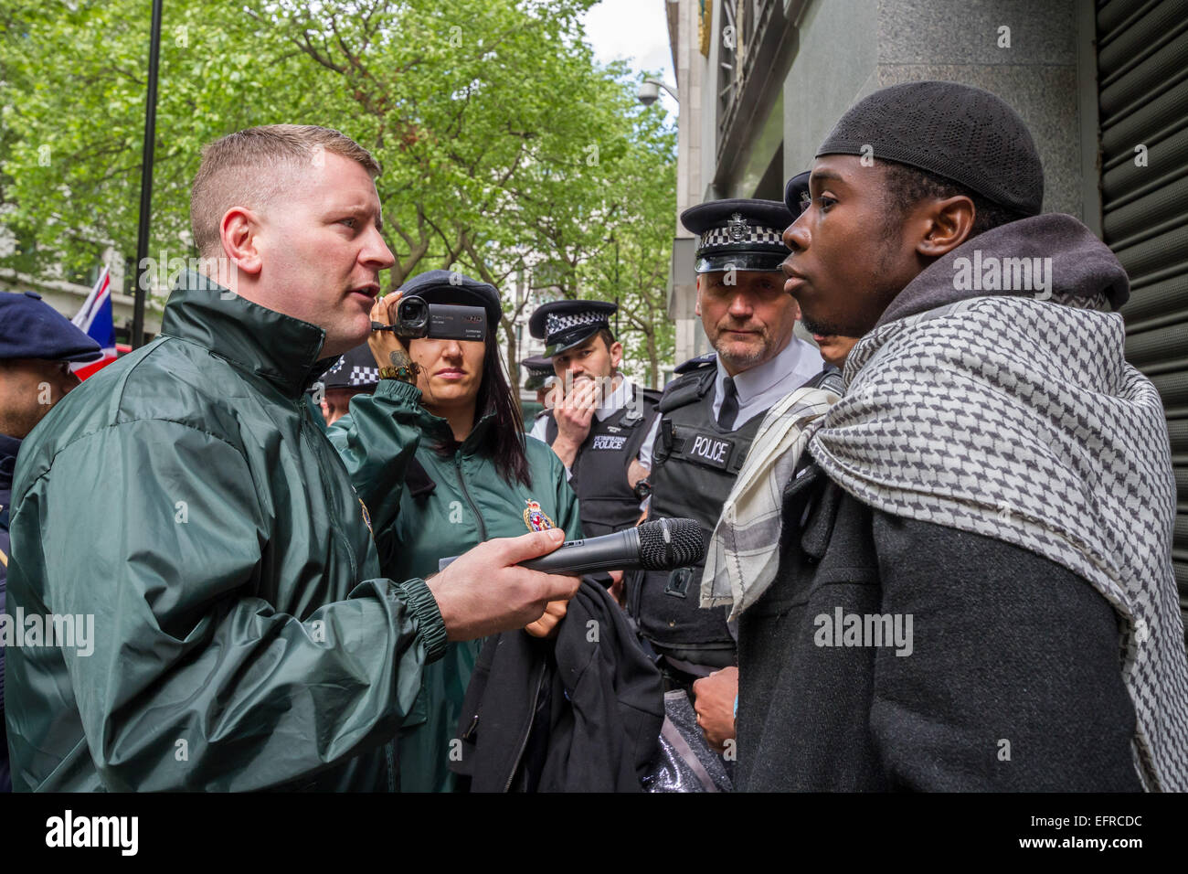 Brustchom Ziamani (R) pictured 9th May 2014 outside the Indian High Commission in London being confronted by Paul Golding (L) of Britain First Nationalist movement.  Brustholm Ziamani, 19, has been remanded in custody after appearing in court to face terror allegations. Ziamani, of Camberwell, south-east London, has been accused of "engaging in conduct in preparation of terrorist acts" on or before 19th August 2014. Mr Ziamani was arrested in east London on Tuesday 19th Aug 2014. He is currently on trial at Old Bailey court. Stock Photo