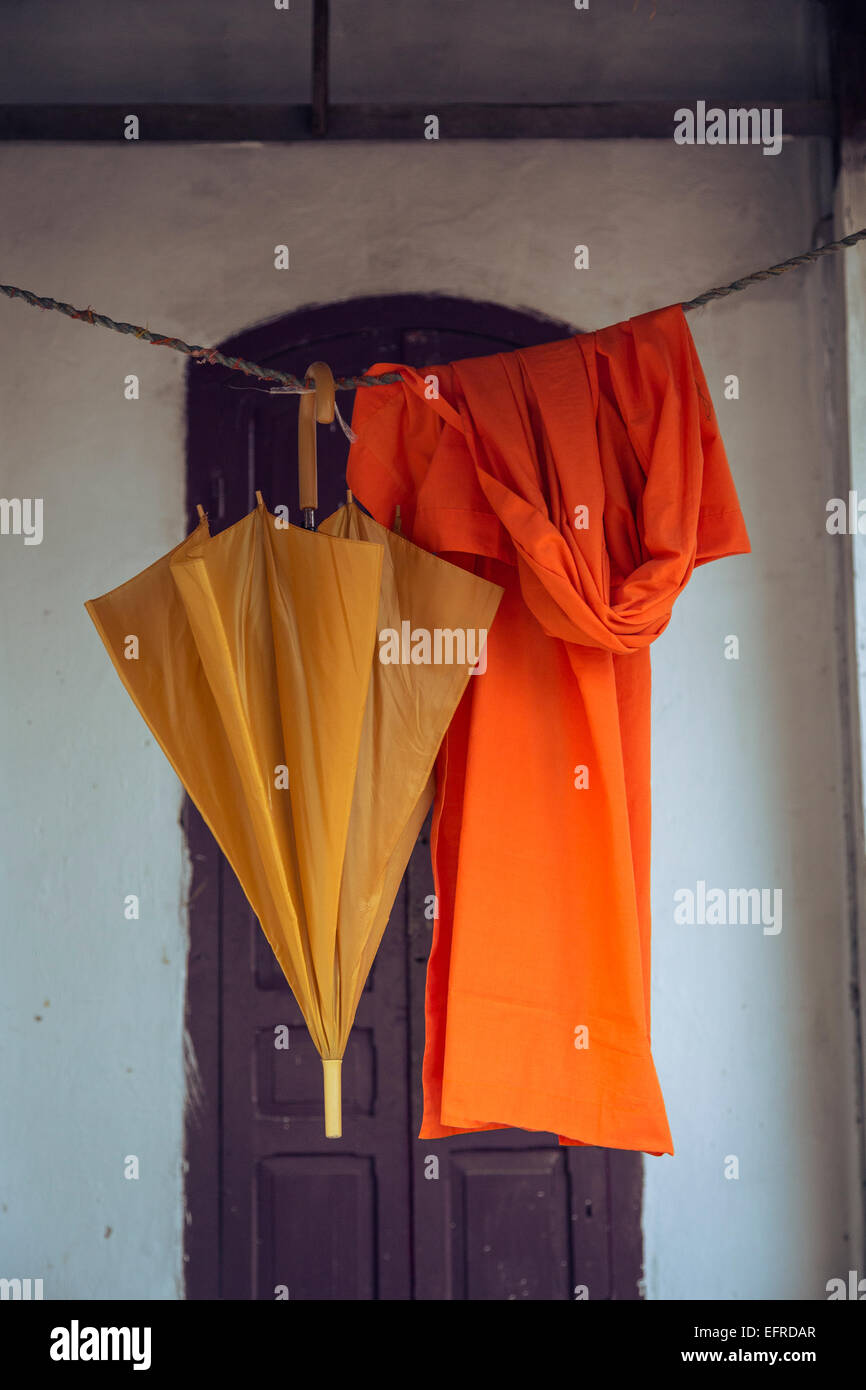 Orange robe and umbrella hanging, Luang Prabang, Laos. Stock Photo