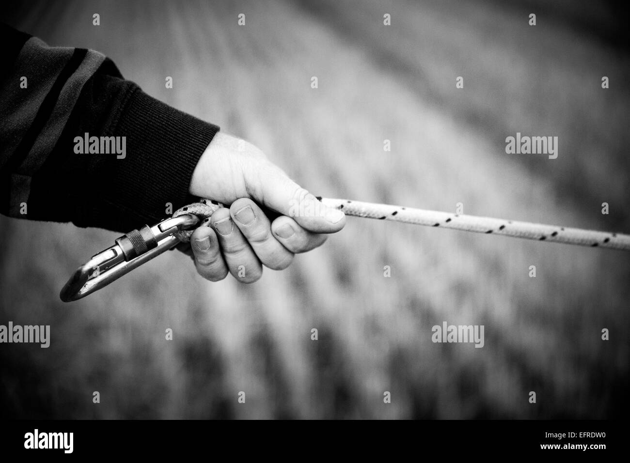 Black and white image of male hot air balloonist holding taut cord Stock Photo