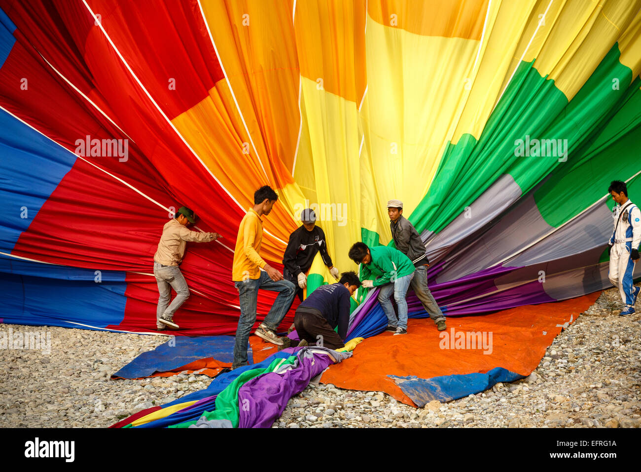 People folding a hot air balloon, Vang Vieng, Laos. Stock Photo
