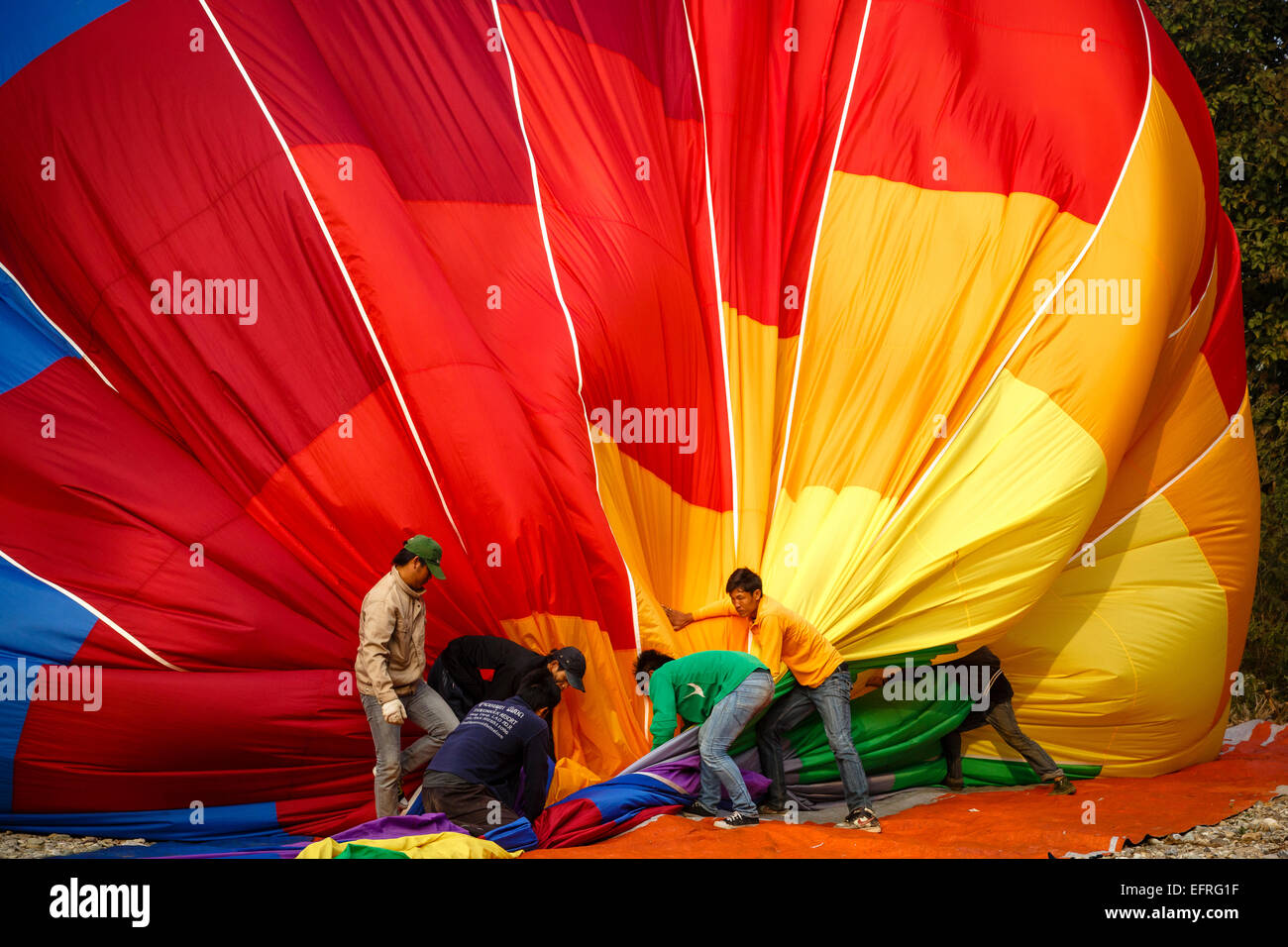 People folding a hot air balloon, Vang Vieng, Laos. Stock Photo
