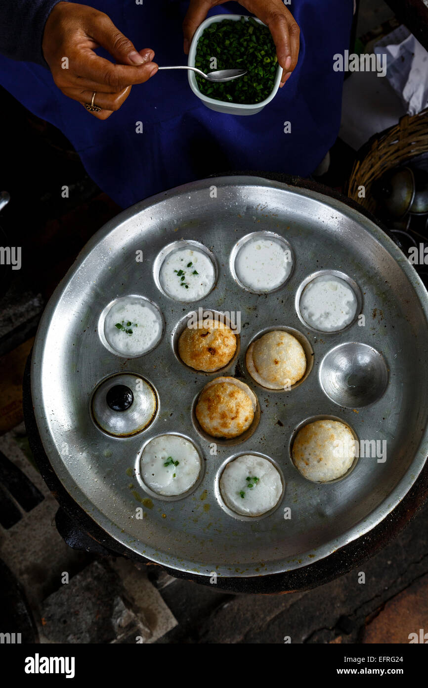 Sweet coconut pancakes made with rice flour & coconut milk, fried in a cast iron mold, Vientiane, Laos. Stock Photo