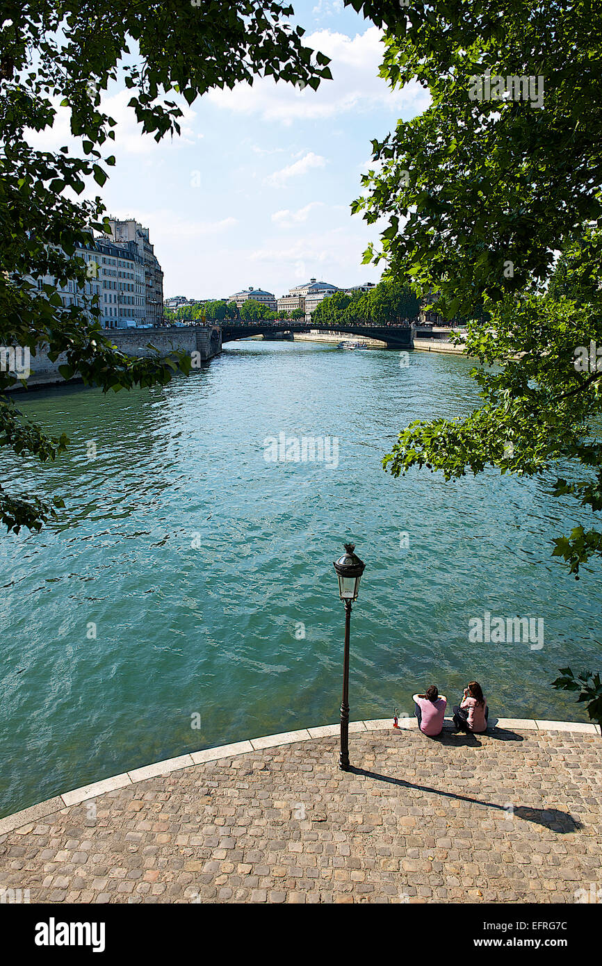 People Sitting along the Seine River, Paris, France Stock Photo