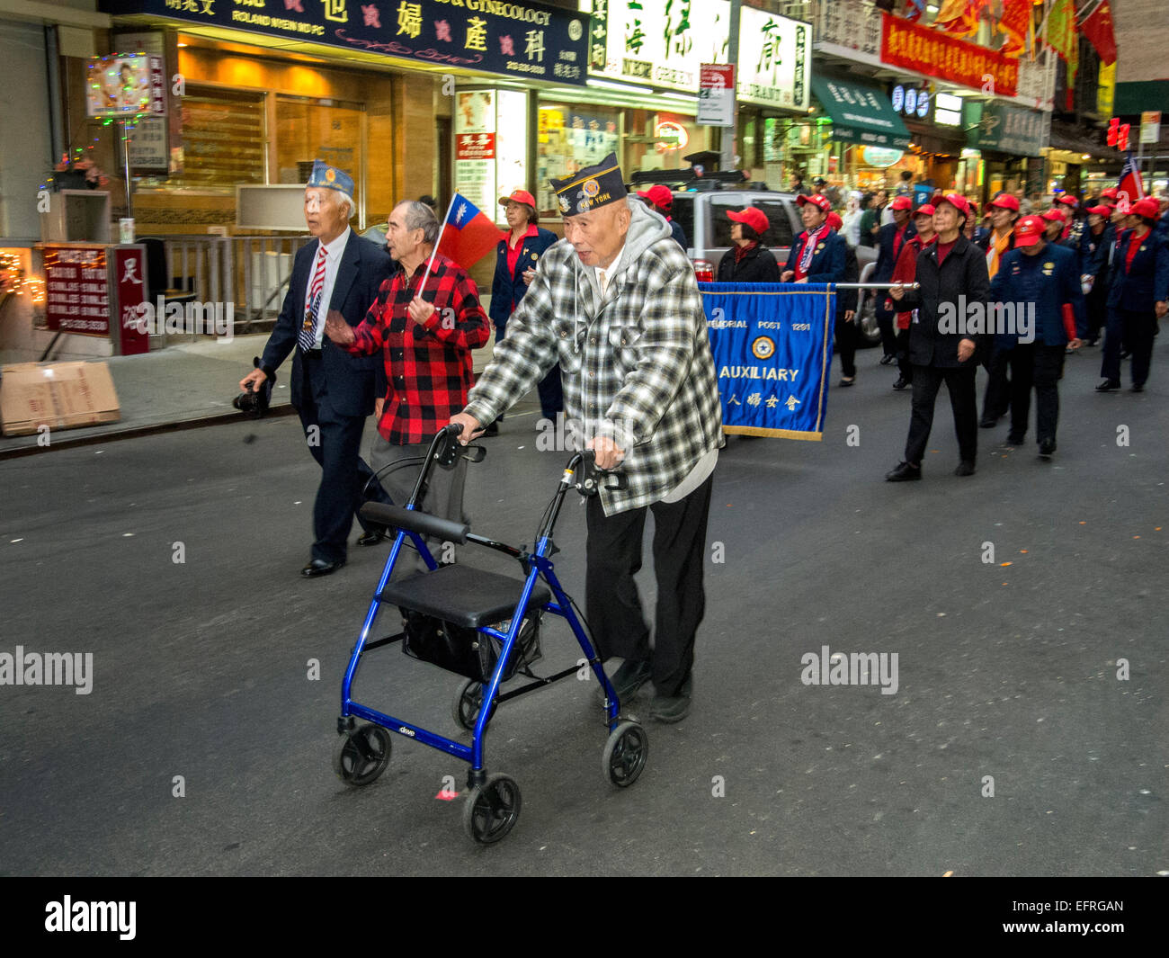 Wearing his American Legion cap, an elderly Chinese war veteran marches in a parade on Bayard Street in New York City Chinatown Stock Photo