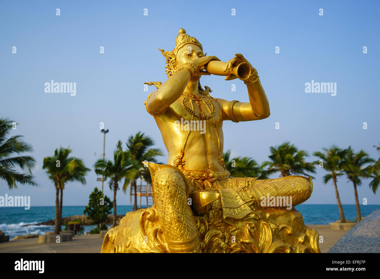 Golden statue of Phra Aphai Mani King blowing his pipe by the sea. Stock Photo