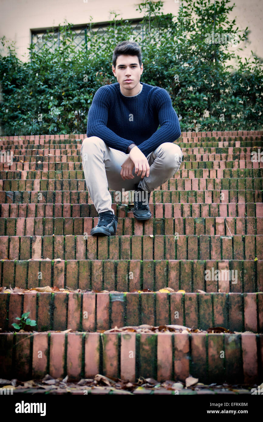 Handsome young man sitting outdoor on old brick stairs Stock Photo - Alamy