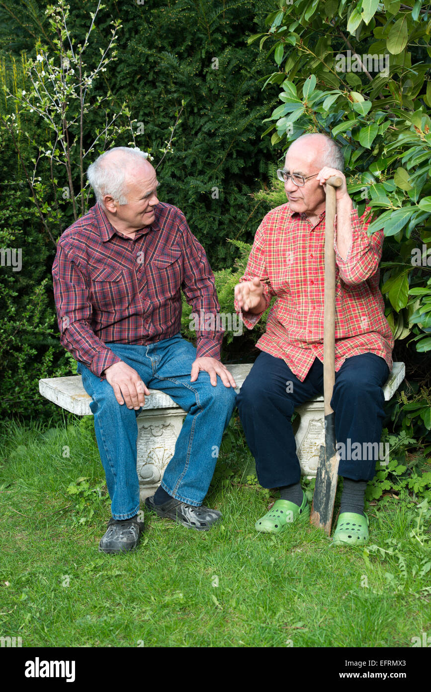 Two old men sitting on bench hires stock photography and