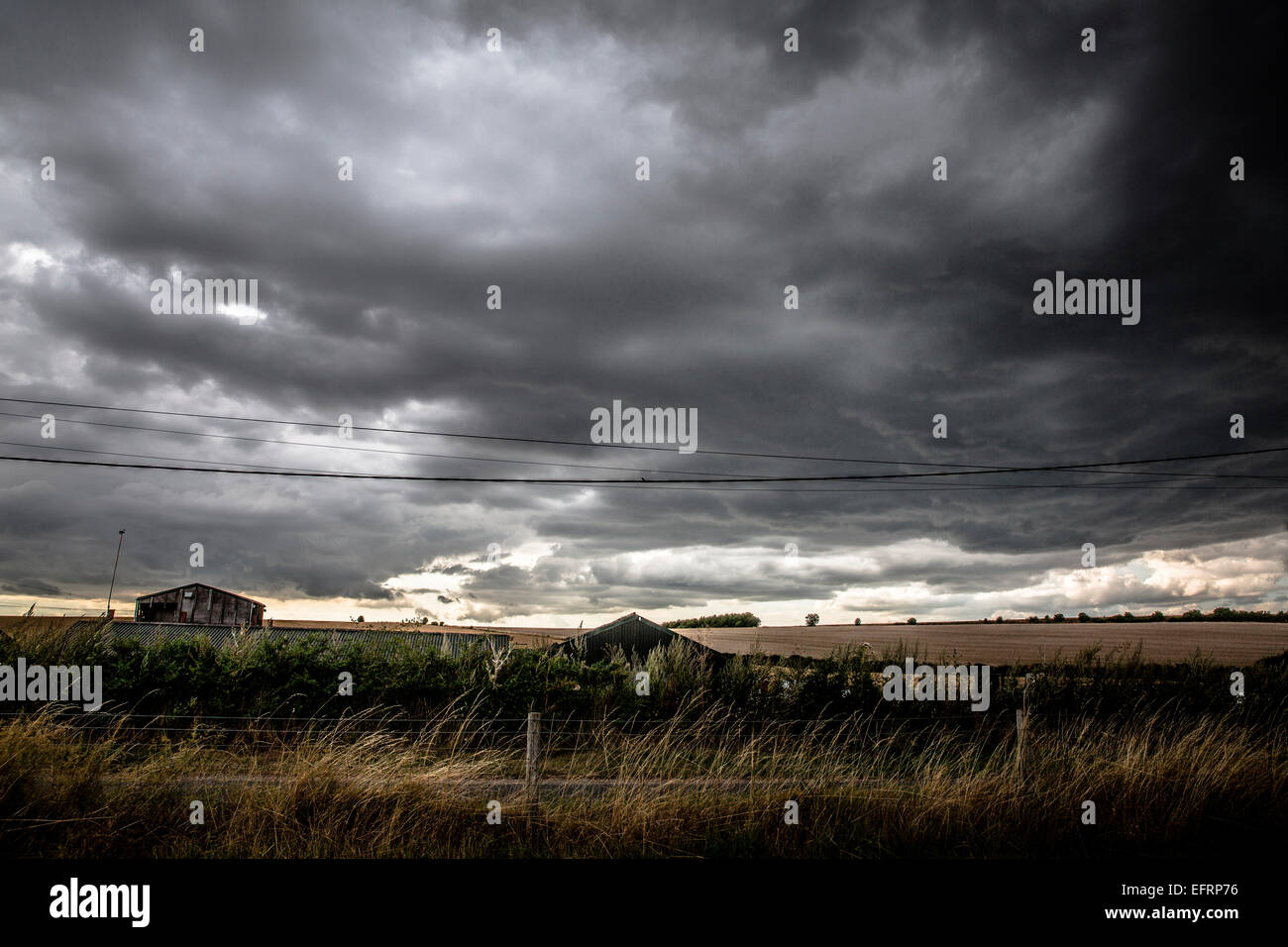 Dramatic sky with grey storm clouds over rural landscape Stock Photo