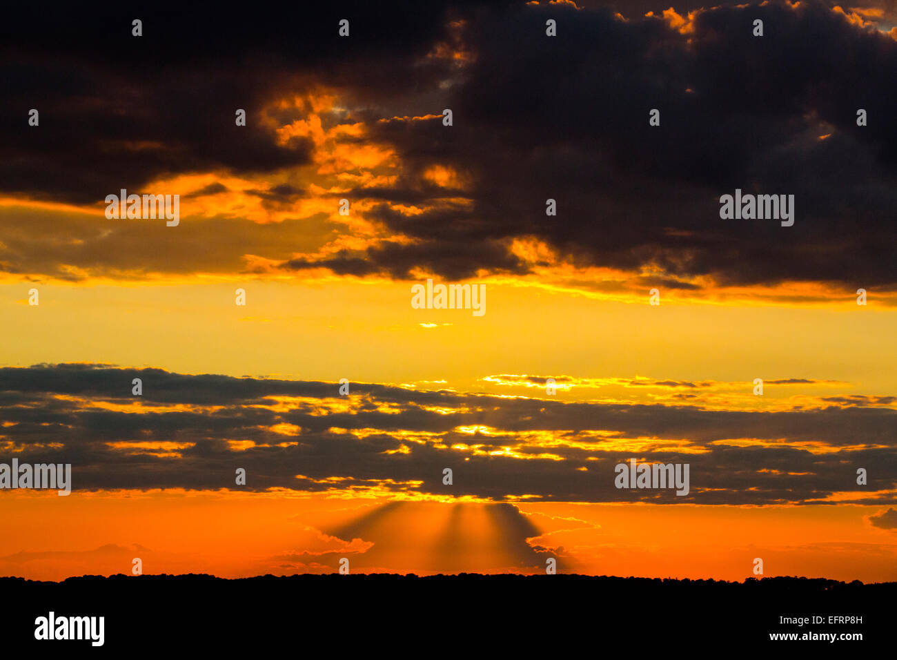 Dramatic skyscape with storm clouds and vivid golden sunset Stock Photo