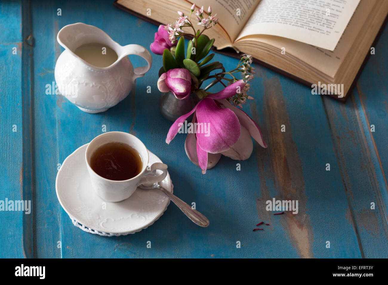 A tea cup and creamer on old wooden table. Top view. Stock Photo