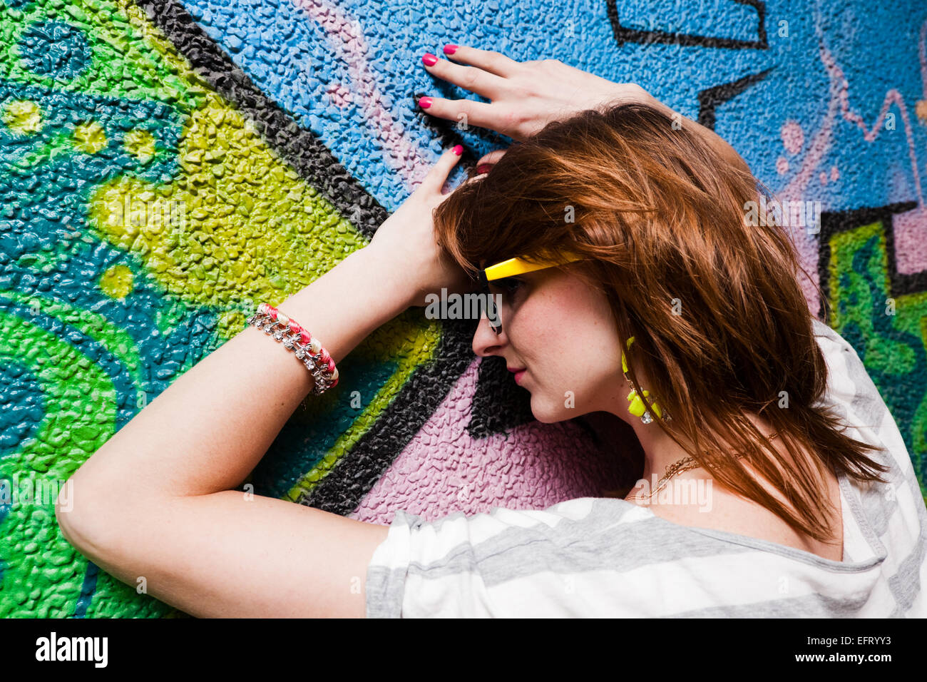 Stylish fashionable girl portrait against colorful graffiti wall. Fashion, trends, subculture. Stock Photo