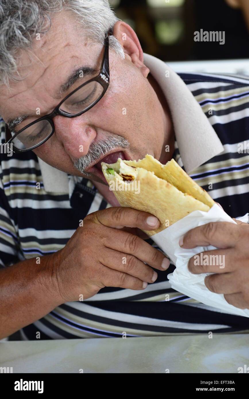 A Cypriot man enjoying a grilled Halloumi sandwich. Stock Photo
