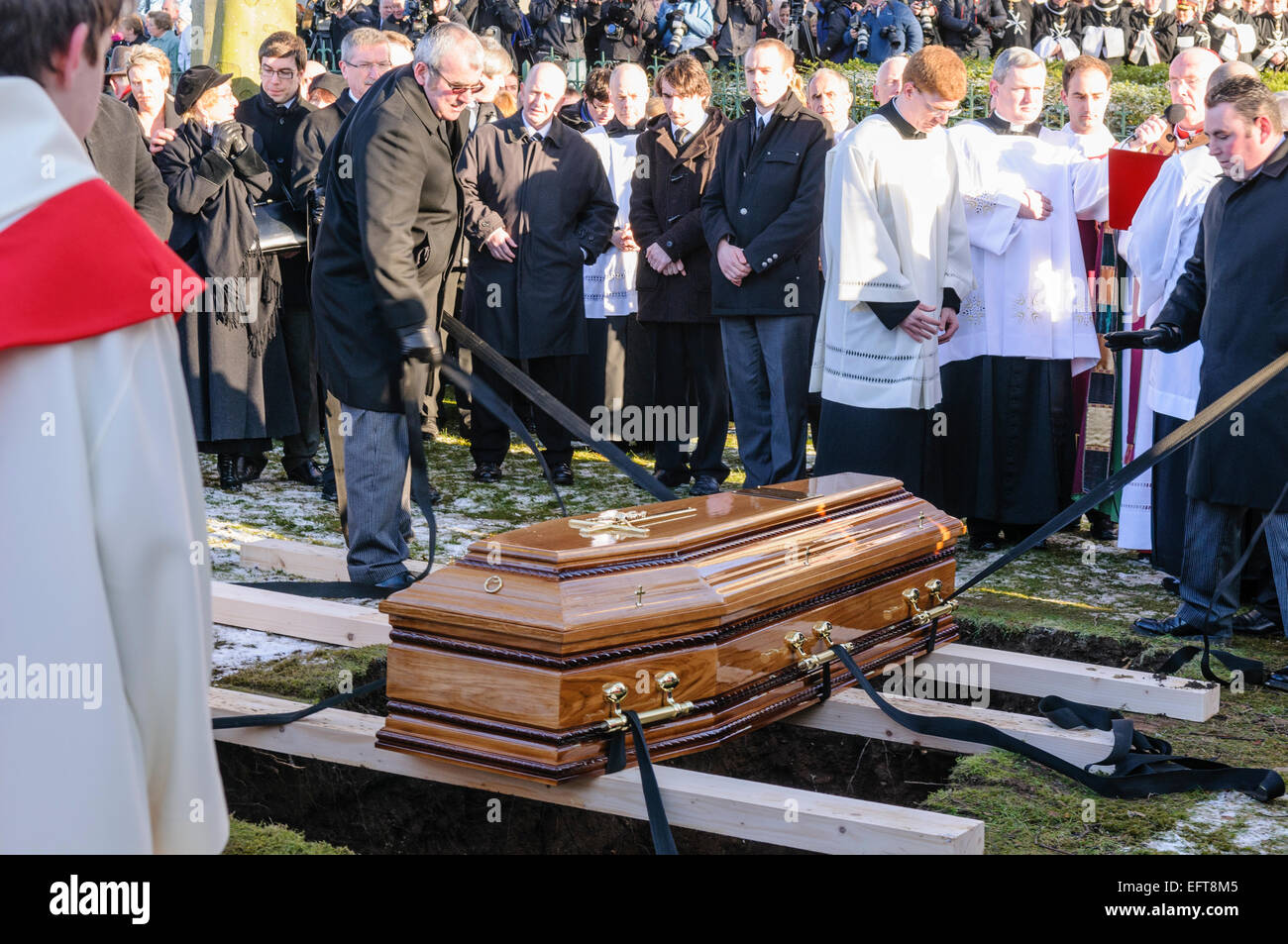 A coffin is prepared to be lowered into a grave Stock Photo